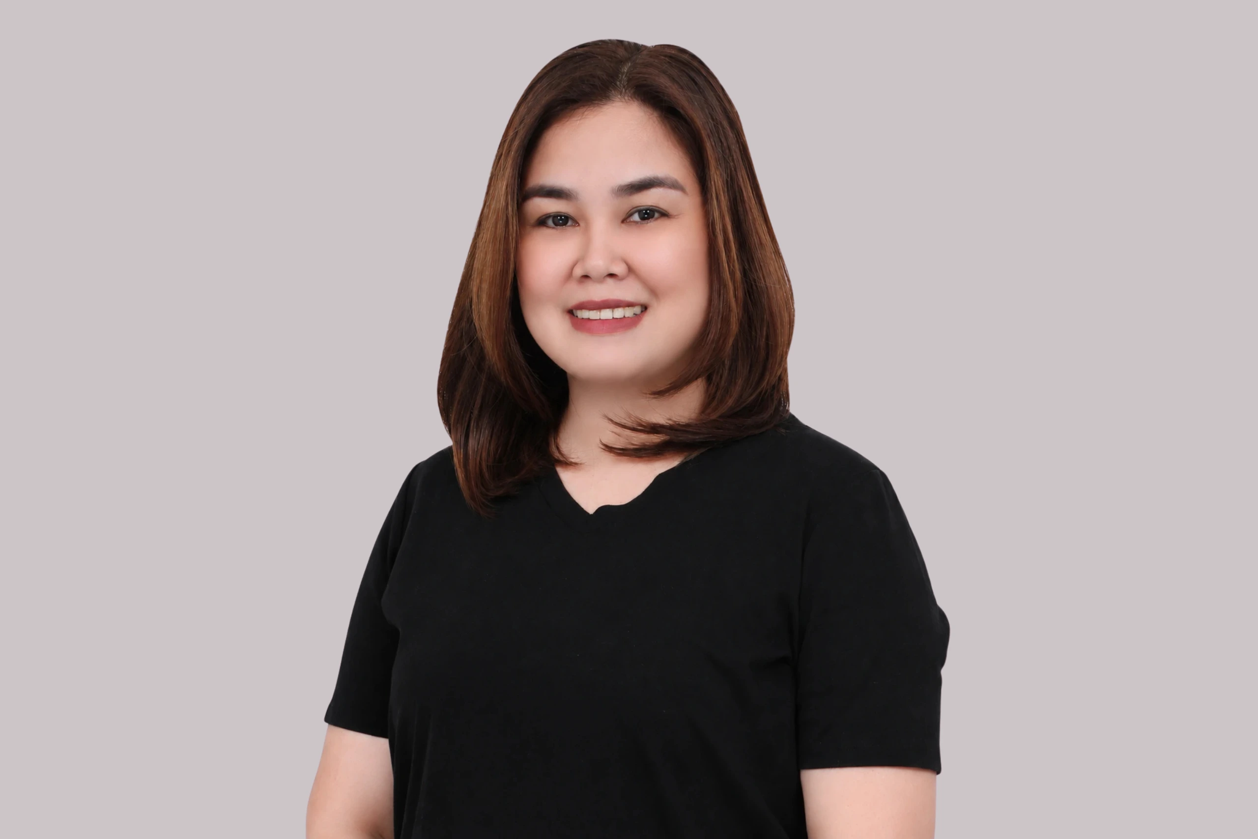 Shera Torollo, SEO Operator at Searchflex, wearing a black top against a light gray background.